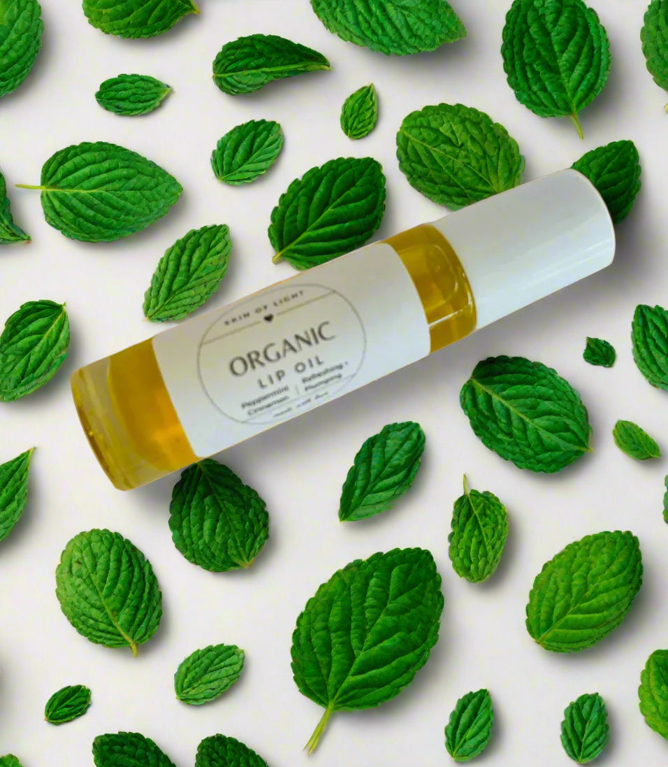 Organic lip oil with green leaves on a light background